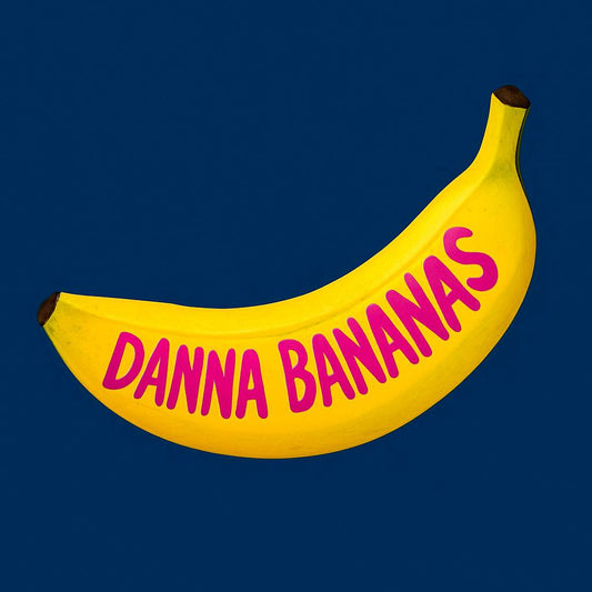 Symbolic illustration of a ripe yellow banana on a navy background with βDanna Bananasβ hand-drawn in fluorescent pink, representing the fresh 2025 website launch.