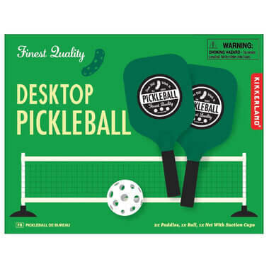 Desktop Pickleball set by Kikkerland with two green paddles, a white ball and a miniature net.