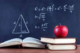 Apple on books with a chalkboard behind