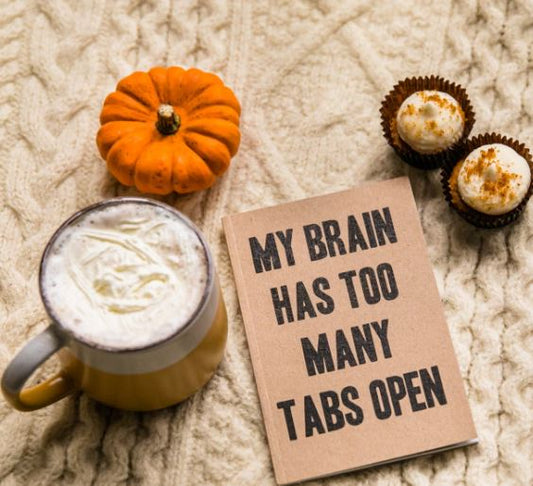 a pumpkin, a hot drink in a mug, two cupcakes and a sign that says "My Brain Has too many Tabs Open"