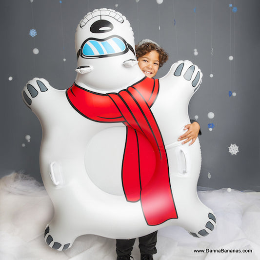 Child holding the inflatable snow bear sled