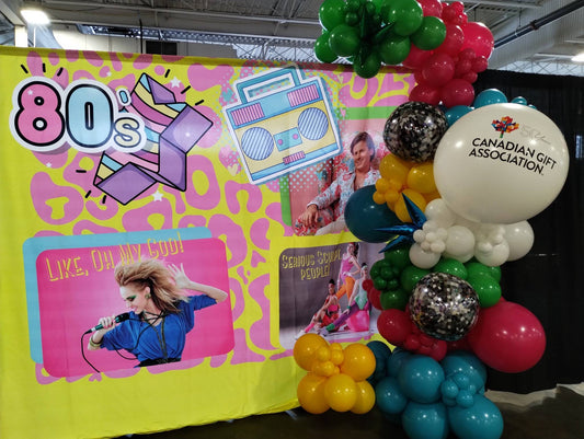 Colourful 50th anniversary display at the Toronto Gift + Home Market celebrating the Canadian Gift Association with balloons and retro-style backdrop.