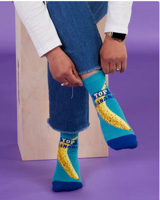 A woman wearing and holding the top of her Top Banana Socks