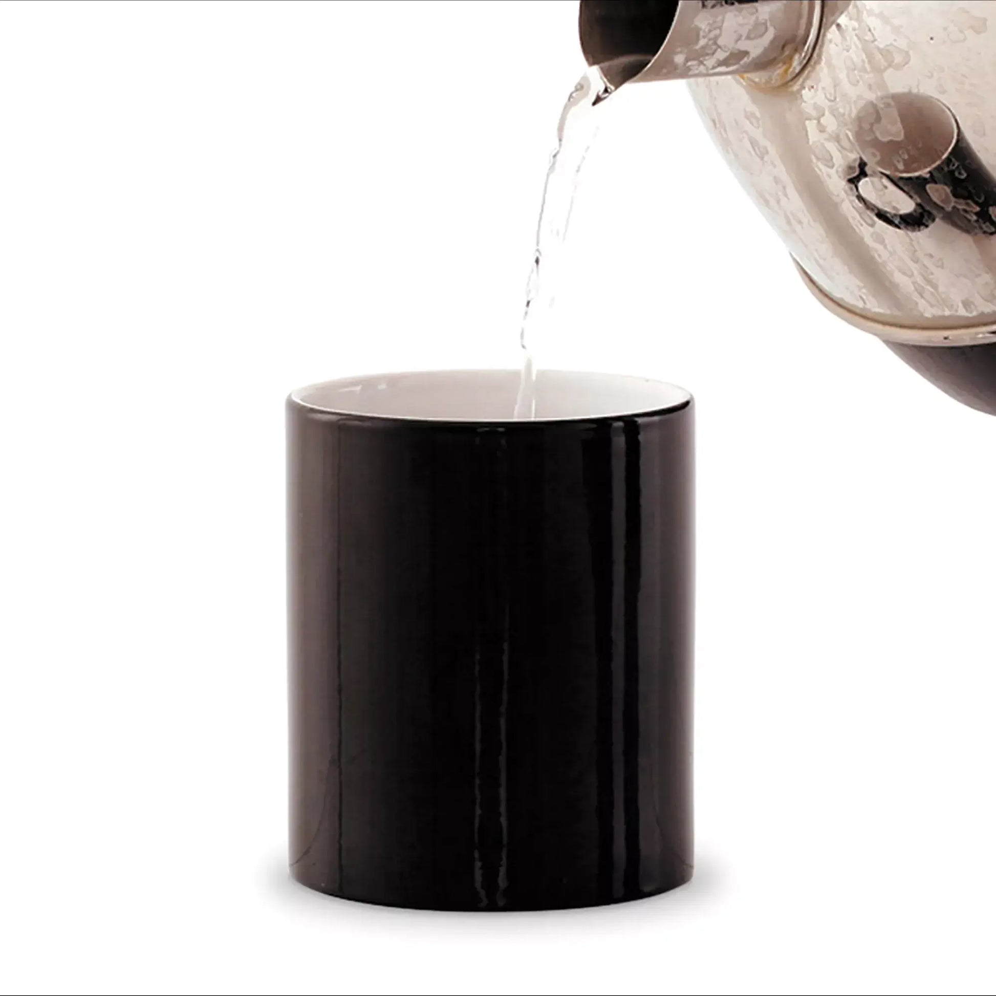 a black mug with a clear pitcher pouring liquid