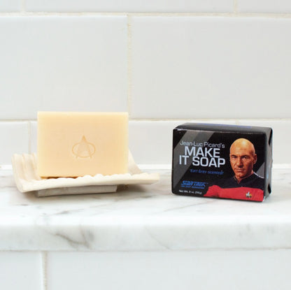 Jean-Luc Picard's Make It Soap Earl Grey Scented Bar of Soap in a Star Trek Themed wrapper and an unwrapped bar of soap on a tray.