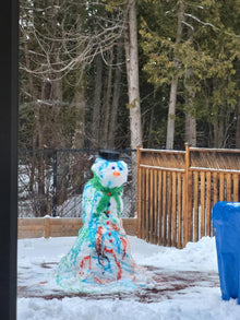 Colourful snowman made with Sno-Man Kit in Ontario backyard, decorated with blue, green, and red spray dye bottles