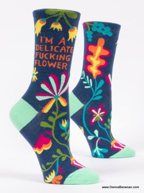 The socks are dark blue, with multi-coloured flowers and the text is, I'm A  Delicate Fucking Flower.    