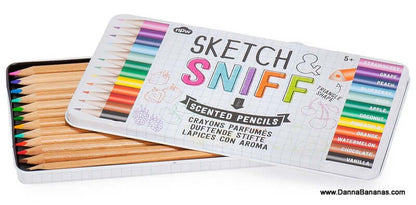 An open tin of 12 uniquely scented colored pencils, each offering a fruity fragrance such as strawberry and vanilla. The box lid features the "Sketch & Sniff Scented Pencils" product name from NPW, accompanied by playful fruit illustrations that complement the delightful scents.