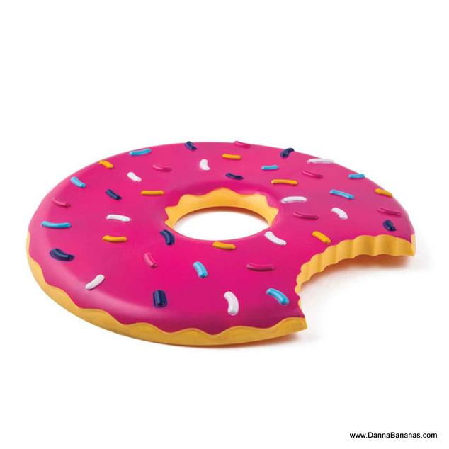 Introducing the Pass the Donut Flying Food Frisbee by Danna Bananas, a large inflatable pool float designed like a giant donut with pink frosting and colorful sprinkles. One side features a whimsical bite mark, adding to its playful appeal.